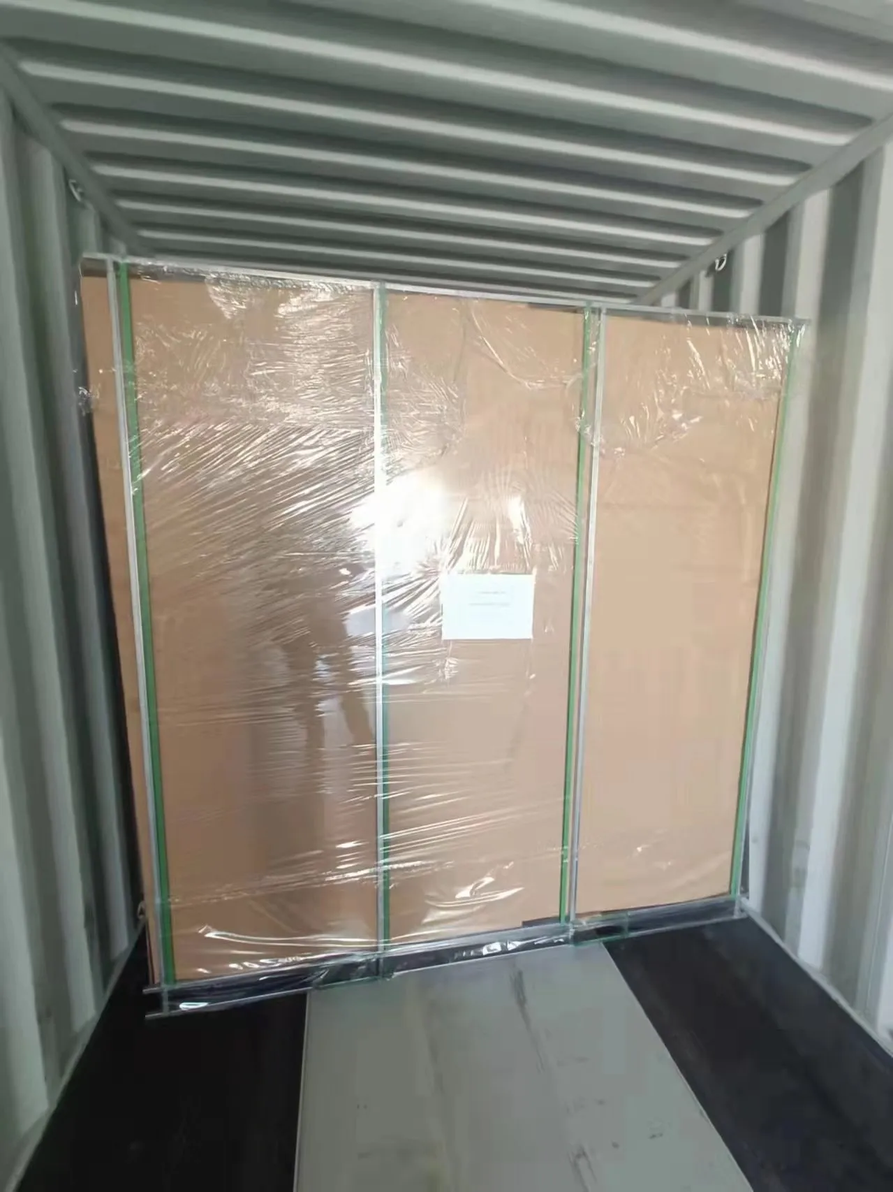 Workers loading aluminum fence products into shipping container